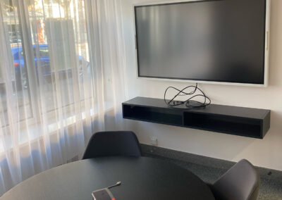 Monitor und Tisch im Meetingraum